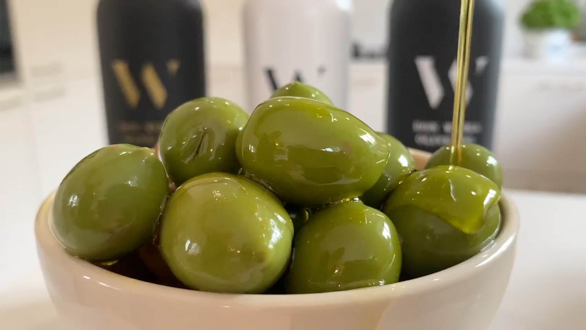 Oliiviöljyä kaadetaan oliivien päälle.